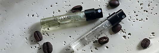 small sample bottle of perfume with coffee beans scattered around